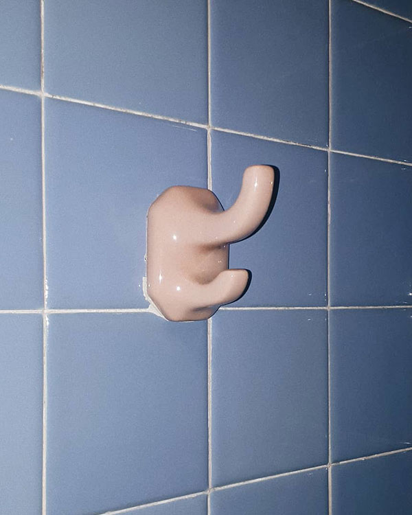 A double hook made of stoneware, pink enamel, fixed to a wall. Found on a private home in Mexico City, Mexico, 2018.