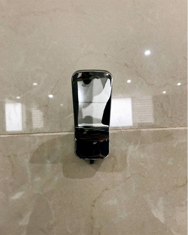 A single hook made of metal, chrome, fixed to a wall. Found on a Sport Club in Mexico City, Mexico, 2021.