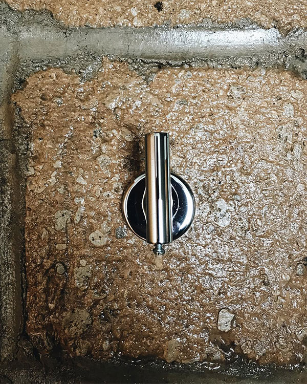 A single hook made of metal, chrome, fixed to a wall. Found on a private home in Aguascalientes, Mexico, 2022.