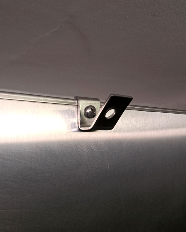 A single hook made of metal, chrome, screwed to a door. Found on a museum in Mexico City, Mexico, 2026.