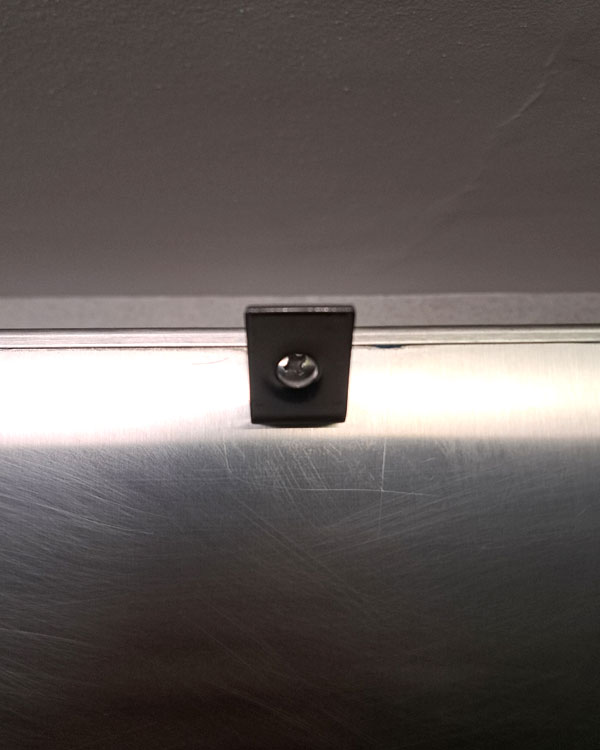 A single hook made of metal, chrome, screwed to a door. Found on a museum in Mexico City, Mexico, 2026.